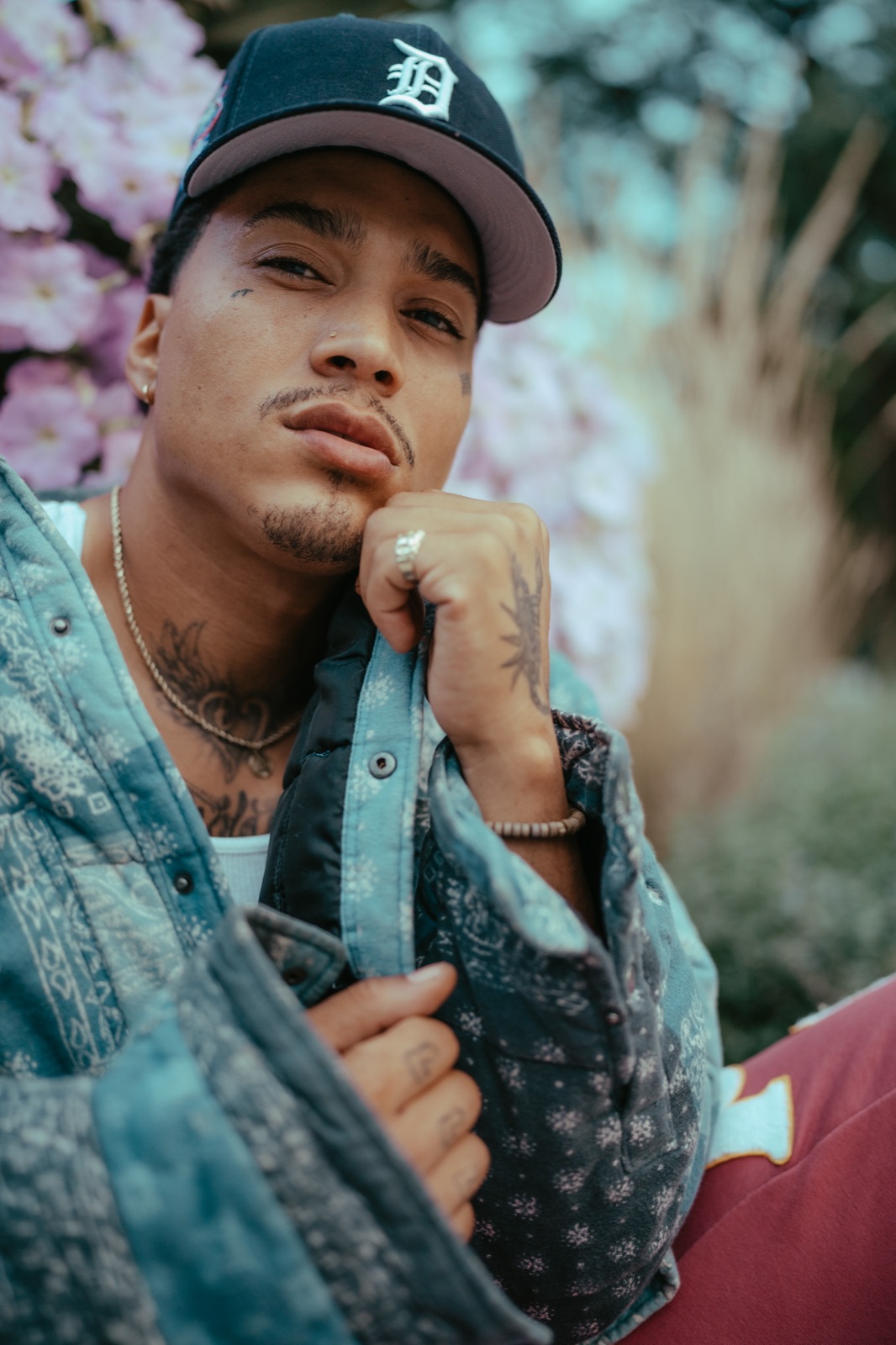 Portrait of a man in a Detroit cap in front of spring blossoms